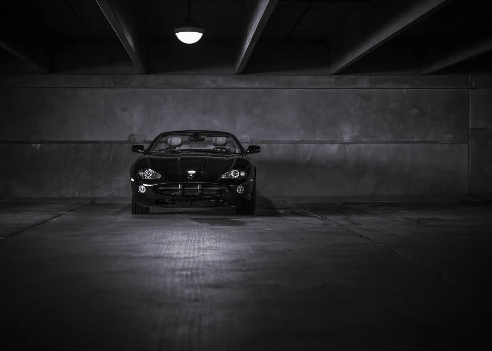 Voiture noire dans un parking, en noir et blanc