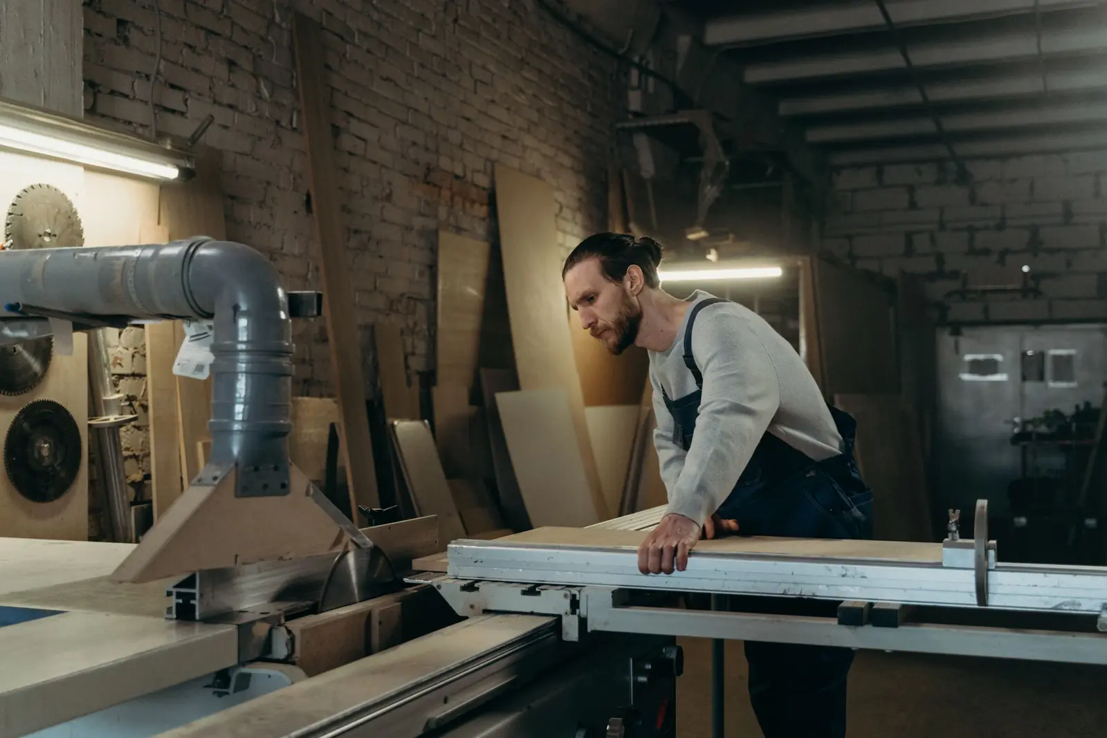 Menuisier découpant une planche dans son atelier