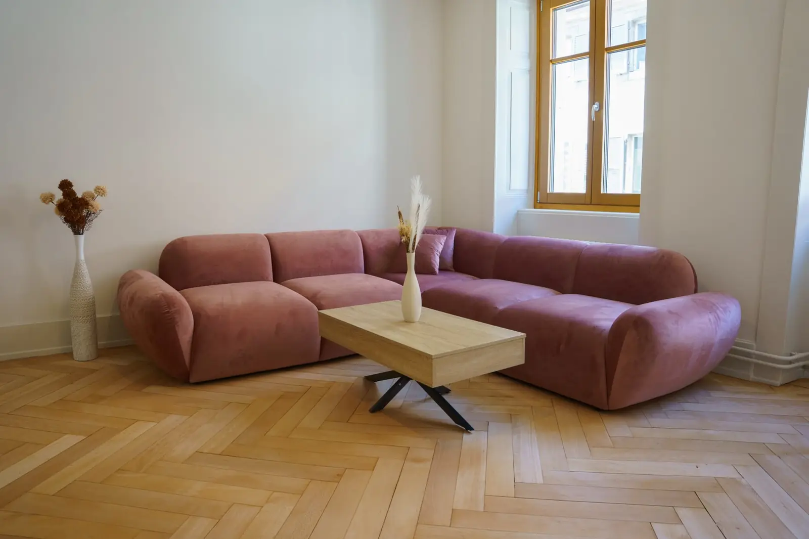 Salon Belle Époque avec canapé rose et parquet d'origine