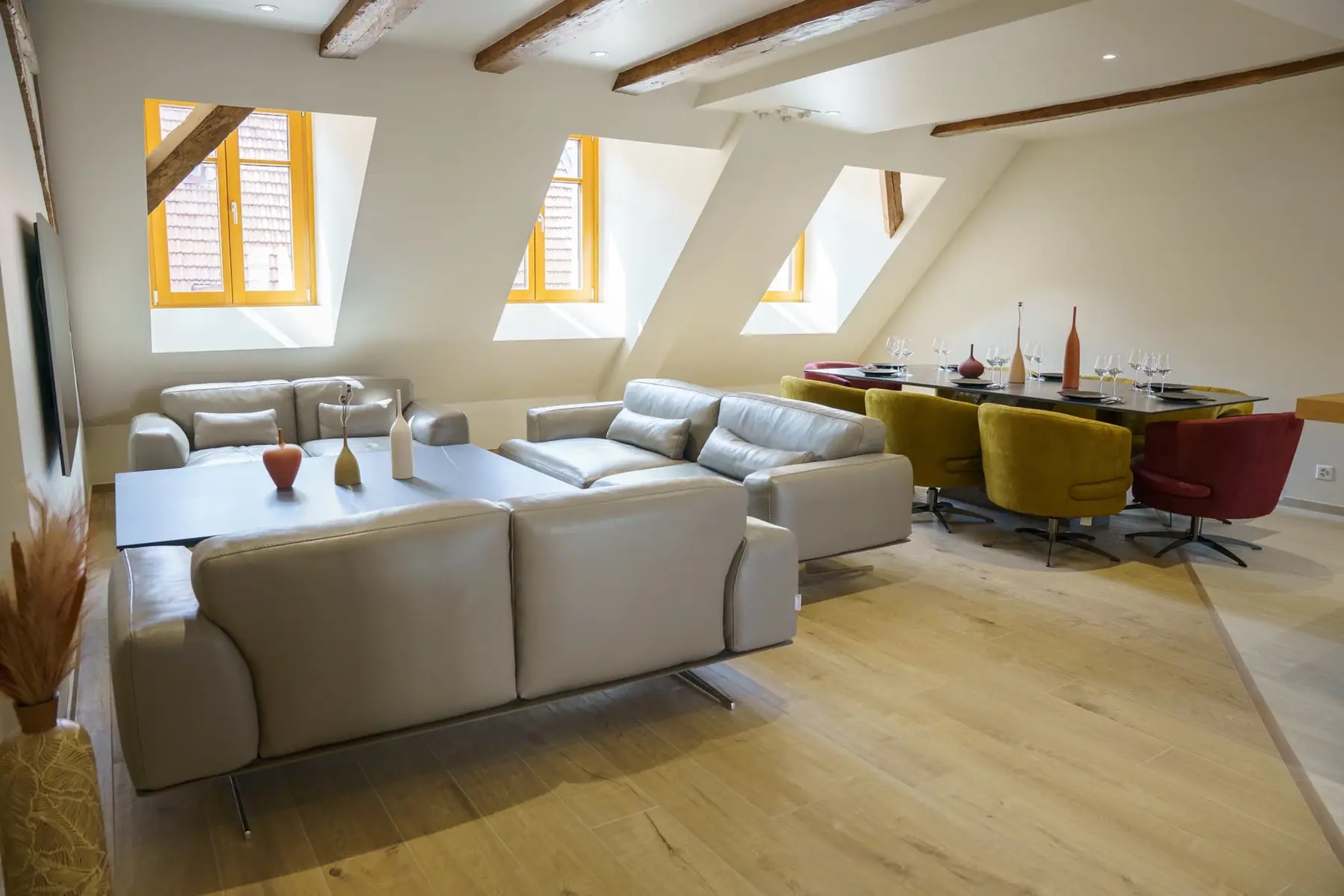 Rooftop attic living room with grey sofas and exposed beams